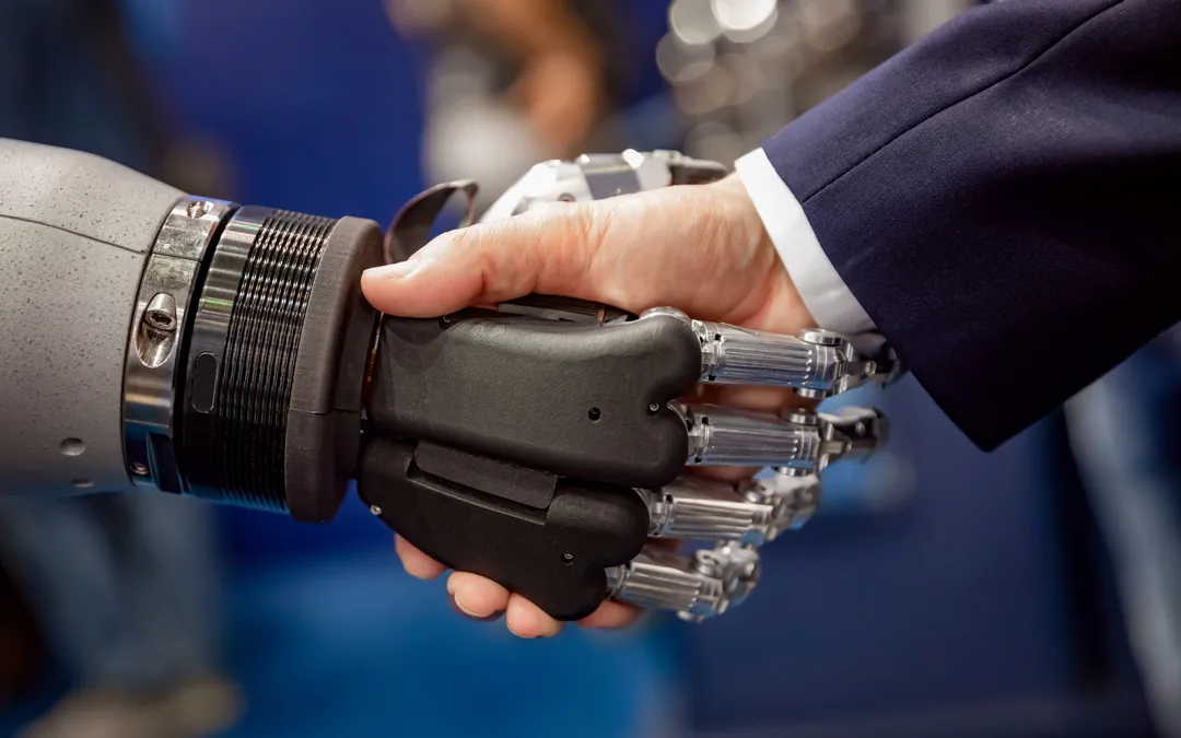 A human hand shaking a robotic hand