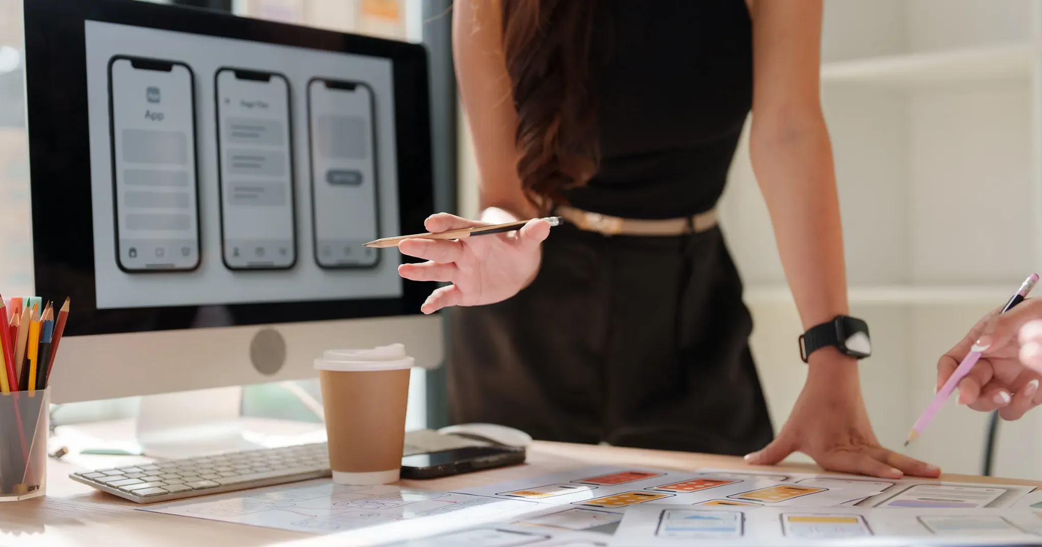 Designer reviewing mobile interface wireframes and reusable website layout components