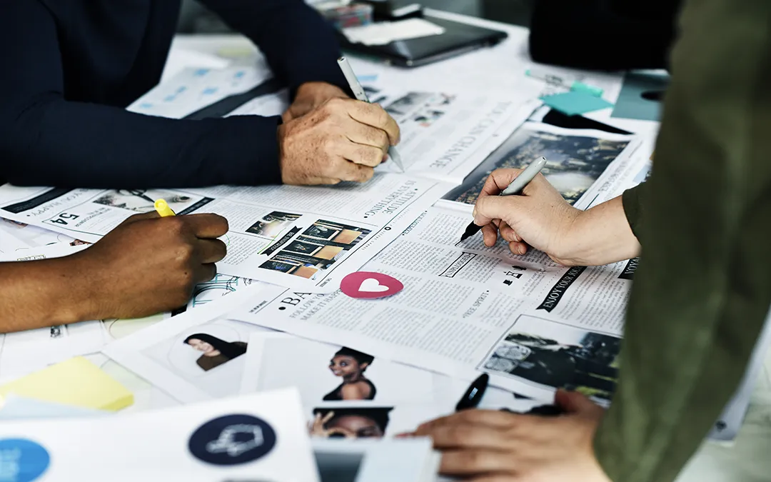 People reviewing printed website content and page layouts before a redesign