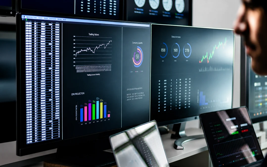 Business data dashboards displayed across several connected computer screens