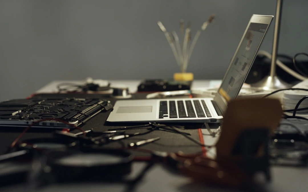 Laptop and technical components on a work desk representing WordPress plugin maintenance